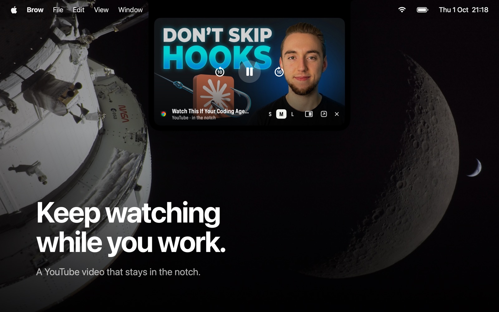 A YouTube video playing inside the notch, with play and skip controls